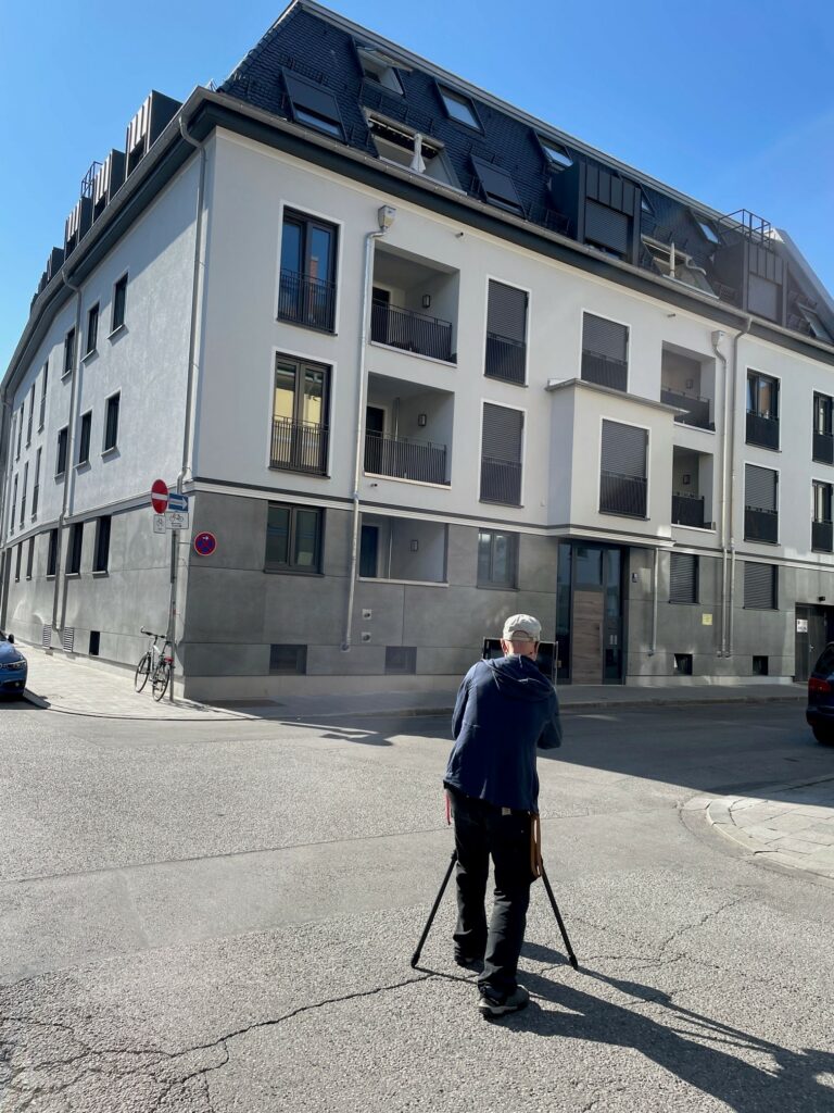Foto von einem Fotografen, der die Fassade eines Mehrfamilienhauses in Schwabing fotografiert