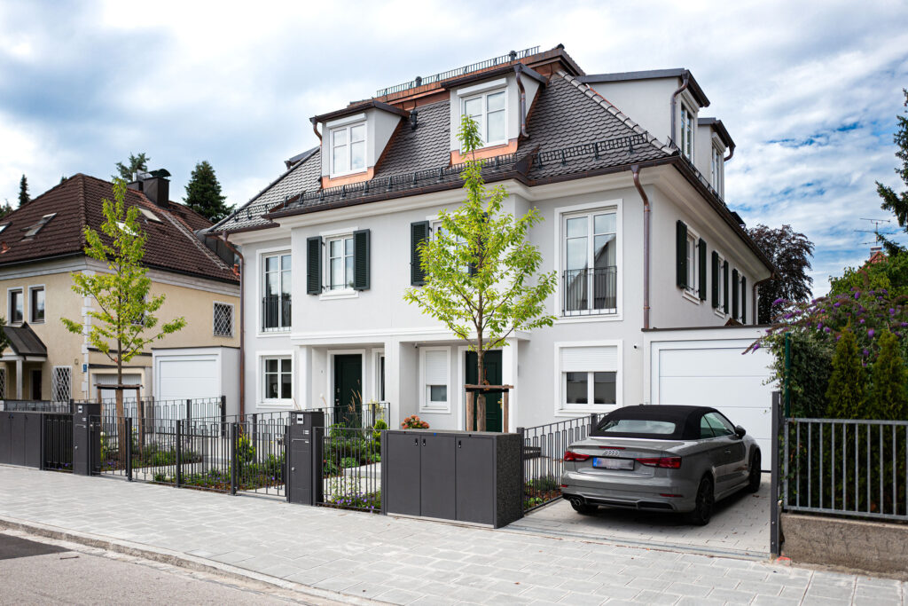 Straßenansicht eines Neubau-Doppelhauses im Villenstil in München Harlaching von DOMINO Bau