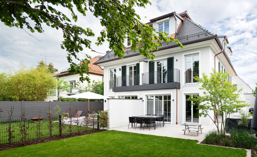 Gartenansicht eines Neubau-Doppelhauses im Villenstil in München Harlaching von DOMINO Bau