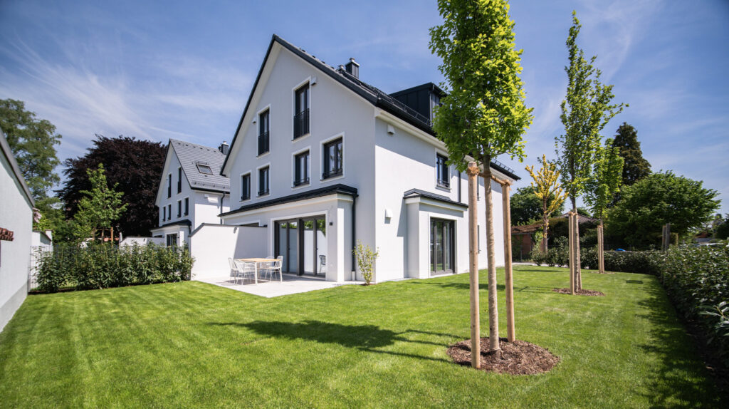 Ansicht Haus mit Garten und Terrasse; Neubau Doppelhaus von DOMINO Bau in München Obermenzing