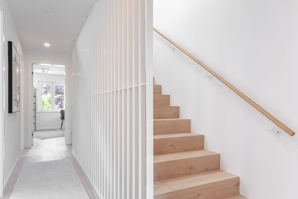 Treppenaufgang im Haus mit Holztreppen; Neubau Doppelhaus von DOMINO Bau in München Obermenzing
