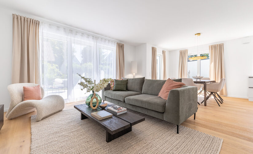 Foto eines Wohnzimmers mit Sofa und Esstisch im Neubau Doppelhaus in Garching bei München von DOMINO Bau