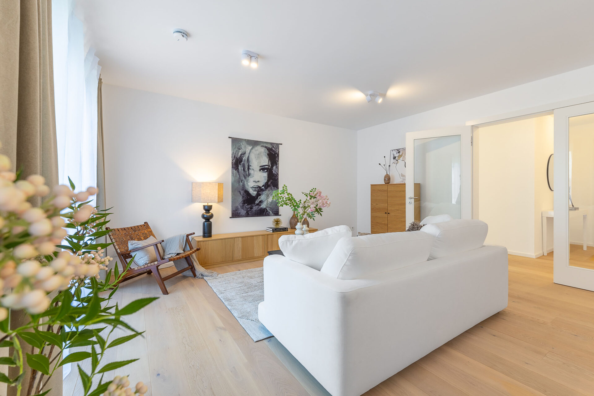 Foto eines Wohnzimmers mit Sofa in einem Neubau Mehrfamilienhauses mit fünf Wohnungen und Tiefgarage von DOMINO Bau in der Thaddäus-Eck-Straße in München-Obermenzing