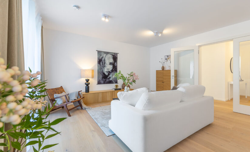 Foto eines Wohnzimmers mit Sofa in einem Neubau Mehrfamilienhauses mit fünf Wohnungen und Tiefgarage von DOMINO Bau in der Thaddäus-Eck-Straße in München-Obermenzing