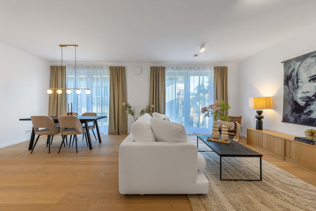 Foto eines Wohnzimmers mit Sofa und Esstisch in einem Neubau Mehrfamilienhauses mit fünf Wohnungen und Tiefgarage von DOMINO Bau in der Thaddäus-Eck-Straße in München-Obermenzing