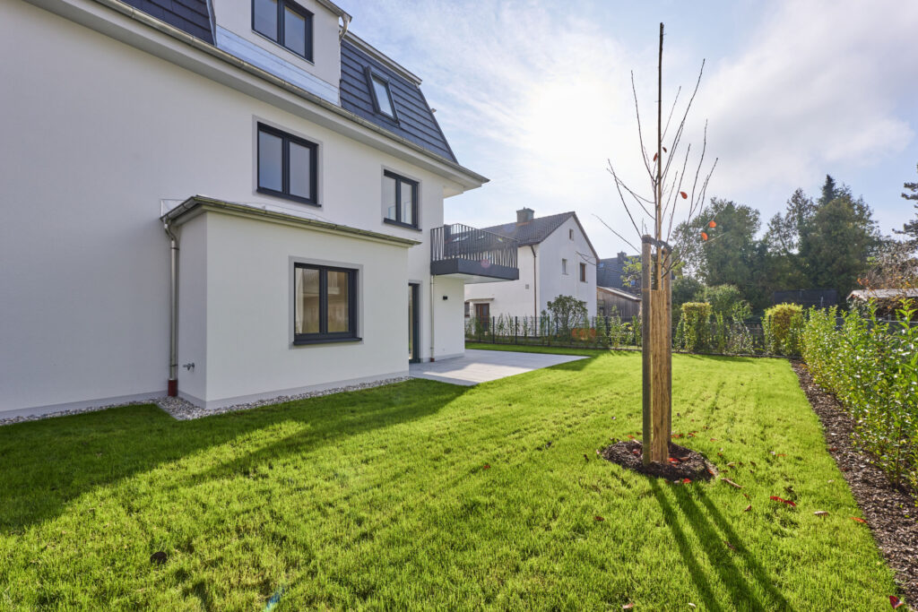 Garten eines stilvollen, modernen Mehrfamilienhauses von DOMINO Bau