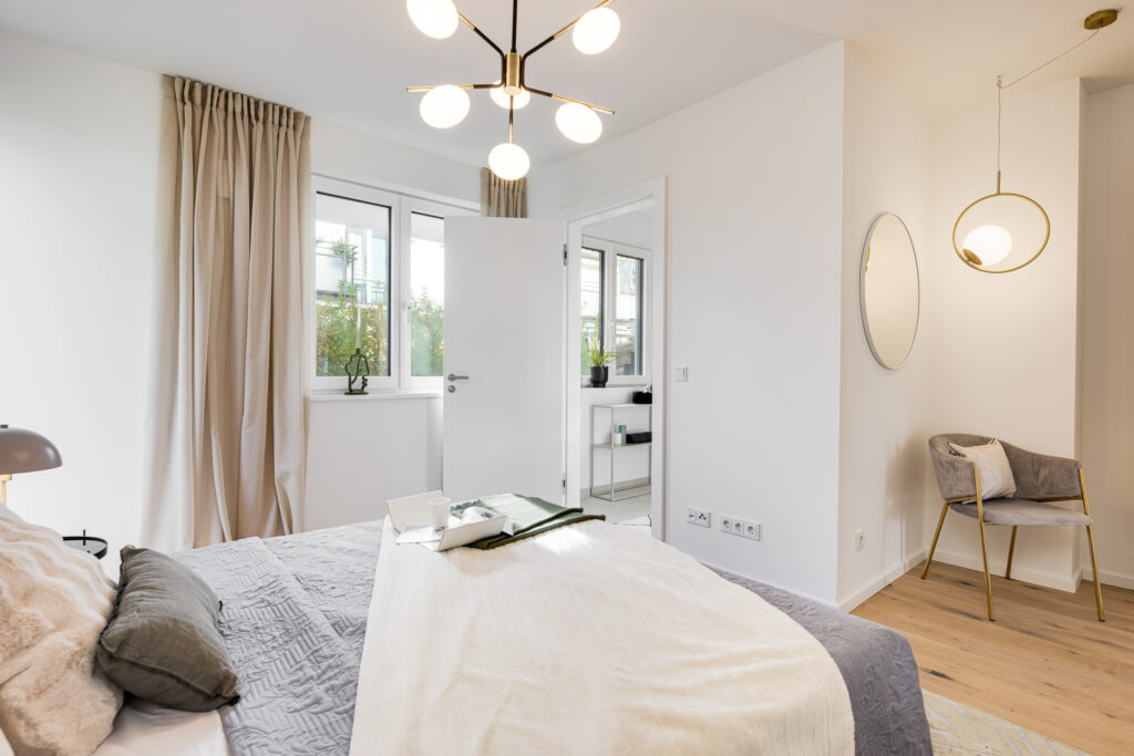 Foto eines Schlafzimmers im Erdgeschoss mit Bad Ensuite einer bezugsfertigen Neubauwohnung in Trudering von Domino Bau