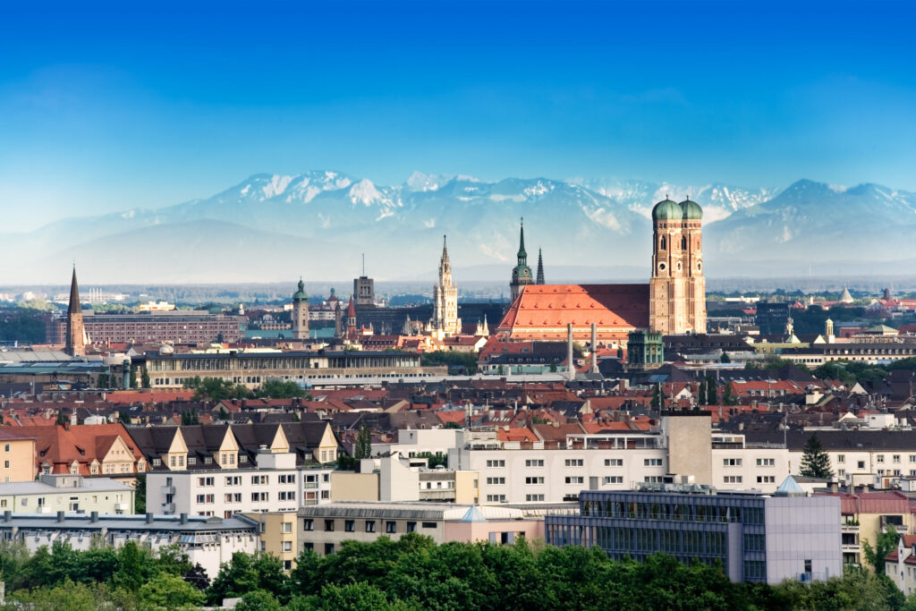 Foto der Münchner Skyline mit den Alpen im Hintergrund