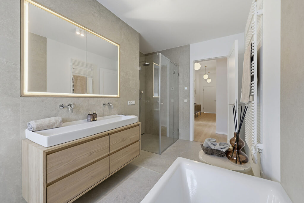 Foto eines Badezimmers im Dachgeschoss eines Mehrfamilienhauses mit drei Wohnungen von DOMINO Bau in München Solln