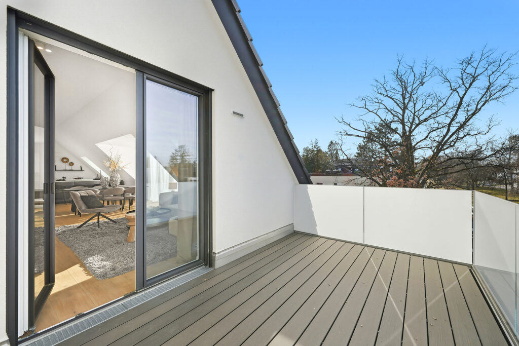 Photo of a balcony on the top floor of a three-unit apartment building by DOMINO Bau in Munich Solln