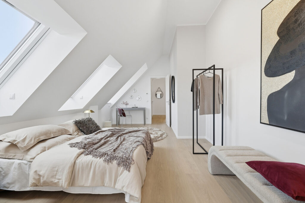 Foto eines Schlafzimmers im Dachgeschoss eines Mehrfamilienhauses mit drei Wohnungen von DOMINO Bau in München Solln