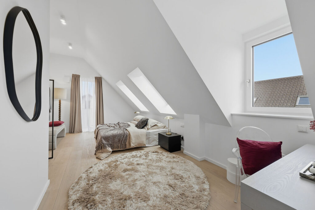 Foto eines Schlafzimmers im Dachgeschoss eines Mehrfamilienhauses mit drei Wohnungen von DOMINO Bau in München Solln