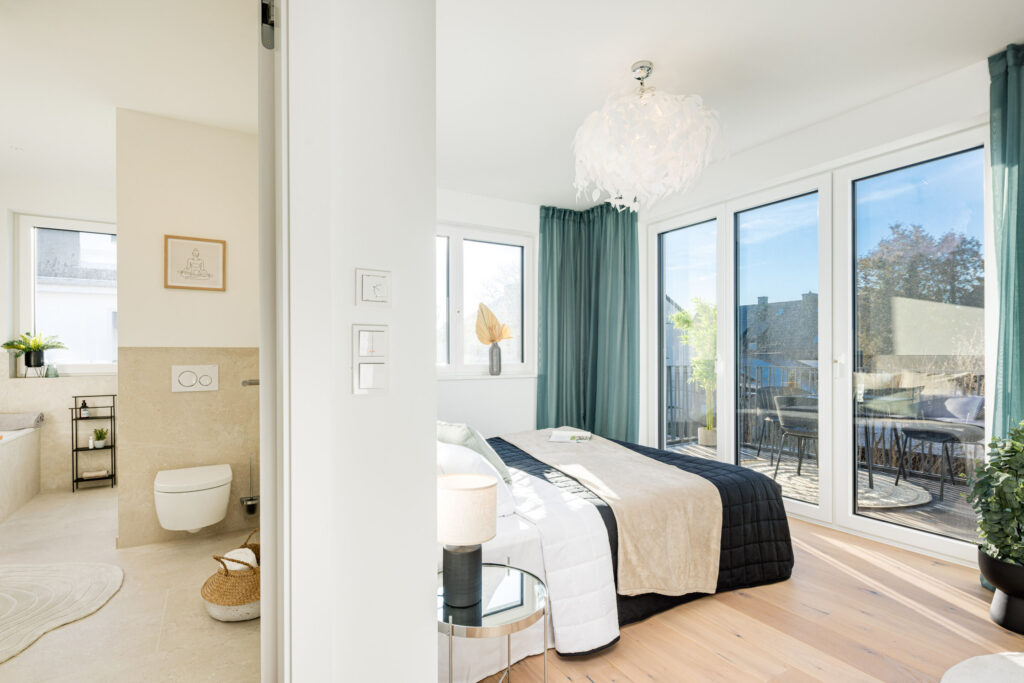 Foto eines Schlafzimmers mit Bad Ensuite und Balkon im Obergeschoss einer bezugsfertigen Neubauwohnung in Trudering von Domino Bau