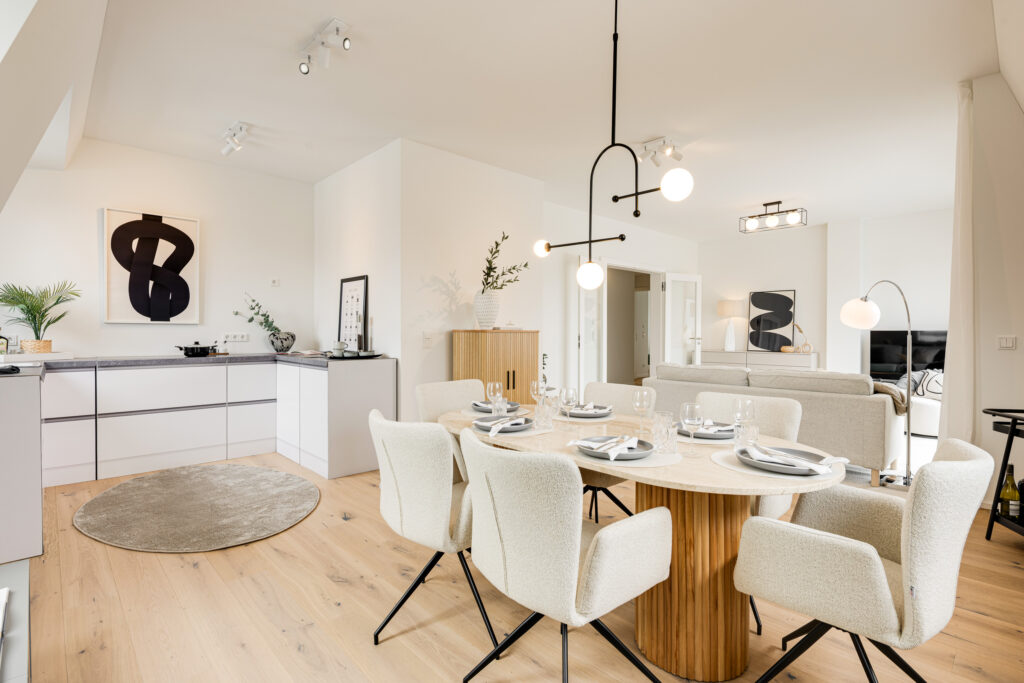 Foto eines Wohnzimmers mit Küche und Esstisch im Dachgeschoss einer bezugsfertigen Neubauwohnung in Trudering von Domino Bau