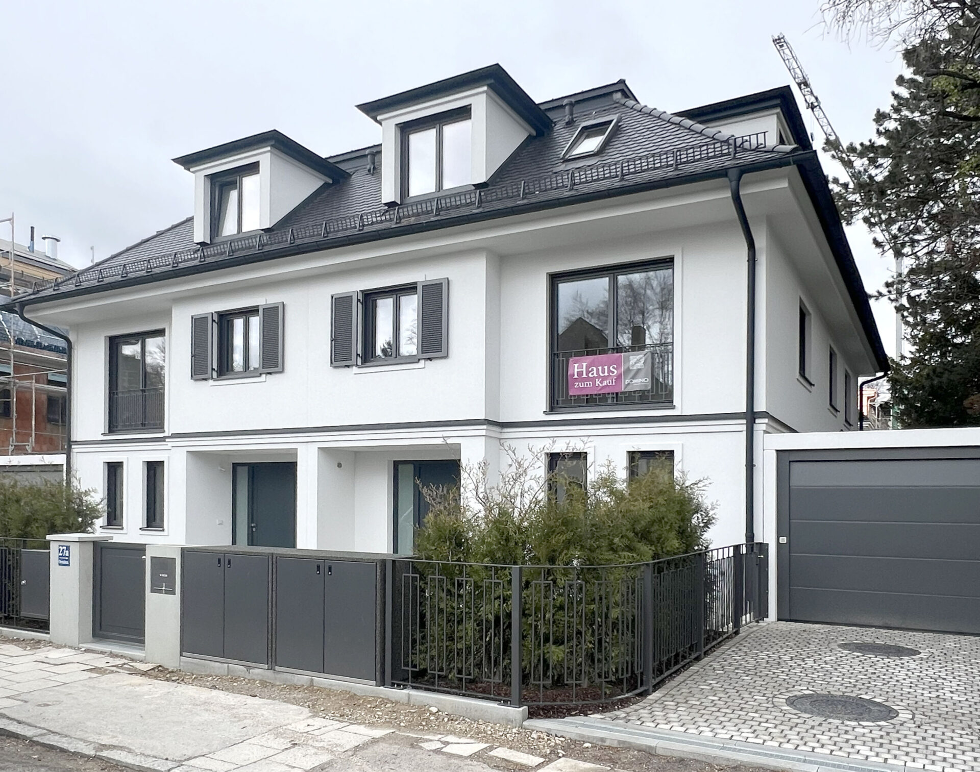 Foto Straßenansicht einer fertiggestellten Neubau Doppelhaushälfte von DOMINO Bau in München-Bogenhausen im April 26
