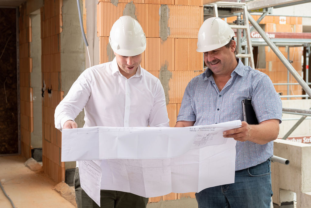 Foto von DOMINO Bau Bauleitern bei der Besprechung des Werkplans auf der Baustelle