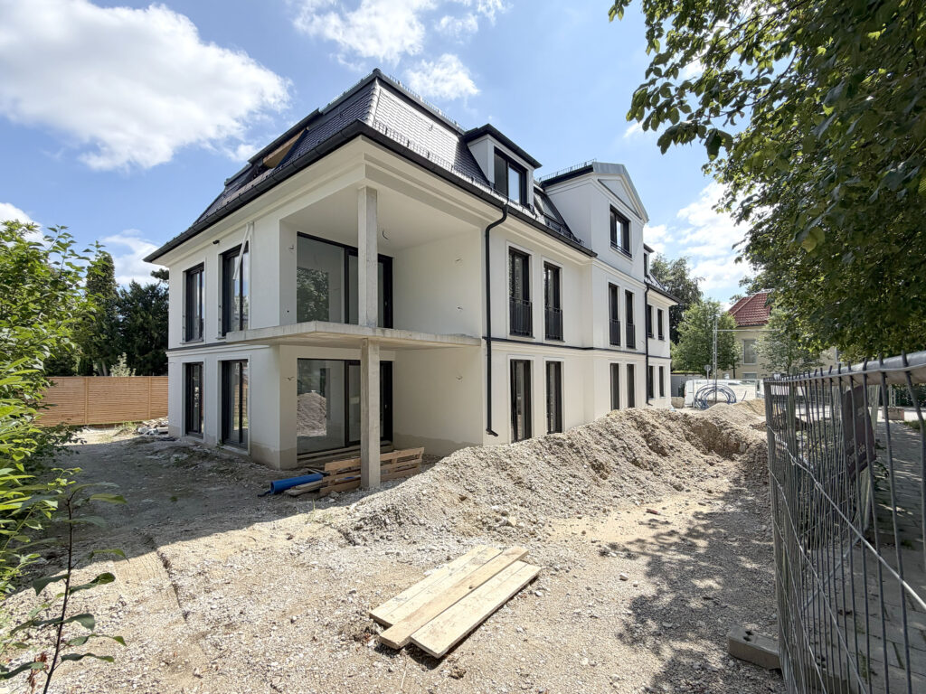Bild Dreifamilienvilla von DOMINO Bau in München Bogenhausen, Tagesansicht , Blick von der Straße, Bautenstand Juli 2026